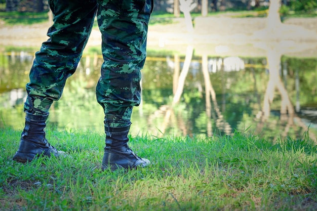 Gambe di soldato in piedi vicino al fiume