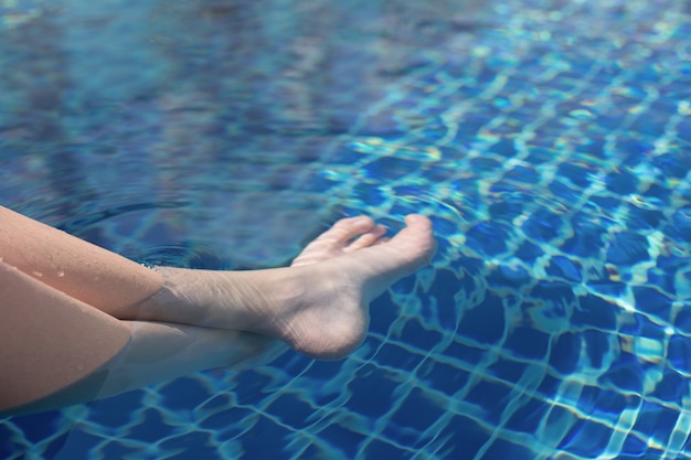 Gambe di un adolescente sott'acqua in piscina Riposo estivo