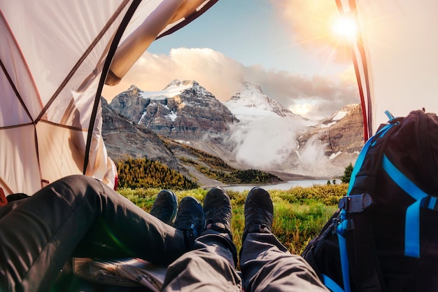 Gambe di un escursionista di coppia che si rilassa all'interno di una tenda con vista sulle Montagne Rocciose nel parco nazionale