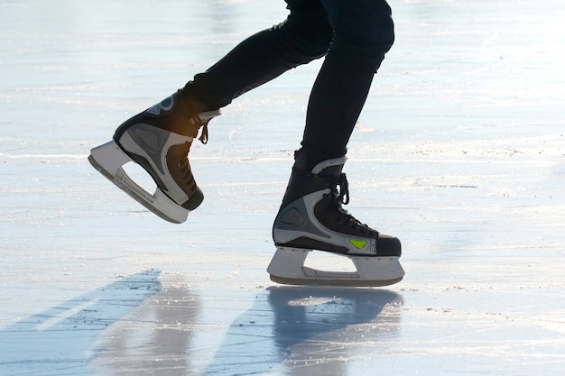 Gambe di un pattinatore sul pattinaggio sul ghiaccio sulla pista di pattinaggio su strada. sport invernali