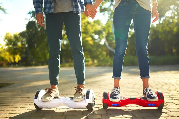 Gambe di uomo e donna che cavalcano insieme sull'Hoverboard all'aperto Futuro della tecnologia per uno stile di vita attivo