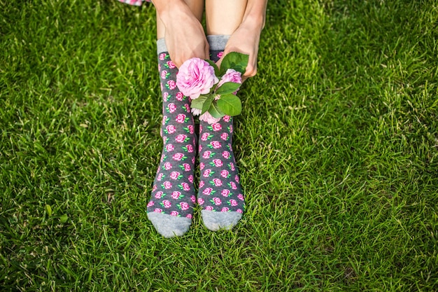 gambe femminili che indossano calzini e tengono un fiore in mano