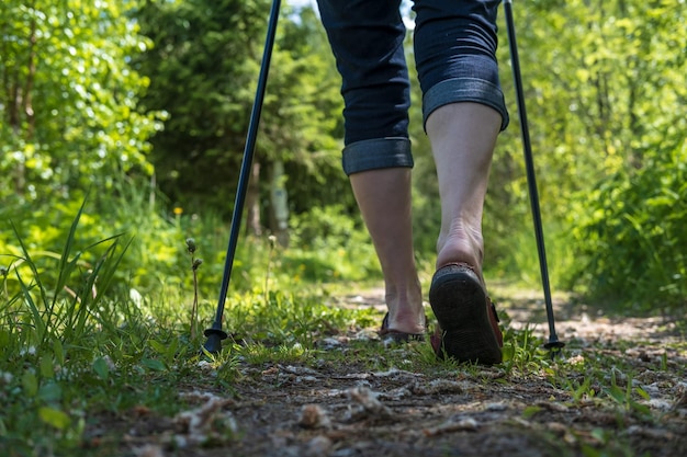 Gambe femminili con bastoncini da nordic walking all'aperto Concetto di uno stile di vita sano