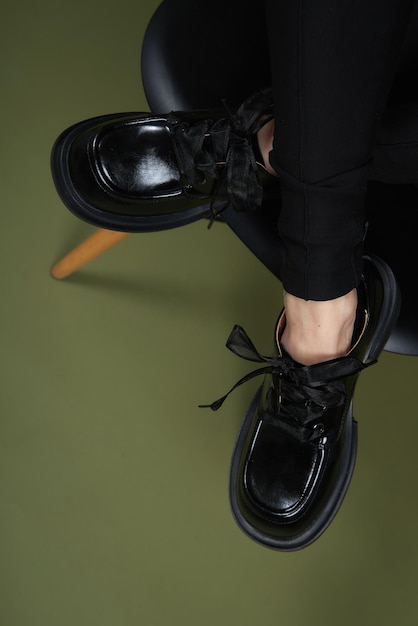 Gambe femminili con stivali neri su verde Foto di concetto di stile di vita casual Scarpe in ecopelle 2022