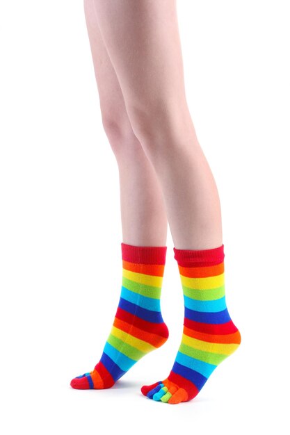 Gambe femminili in calze a righe colorate isolate su bianco