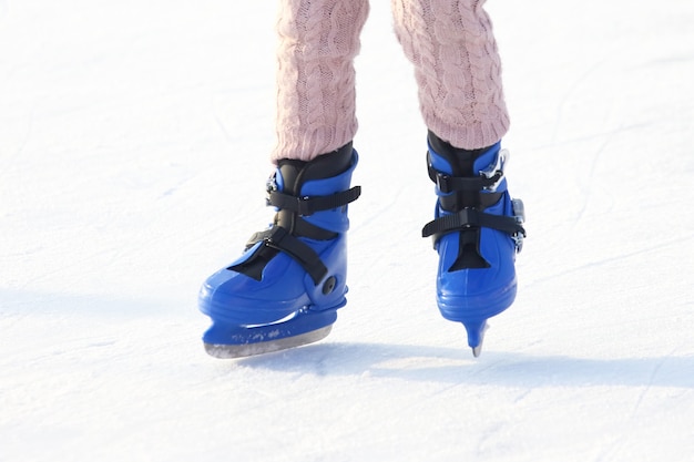 Gambe in blu che pattinano sulla pista di pattinaggio sul ghiaccio