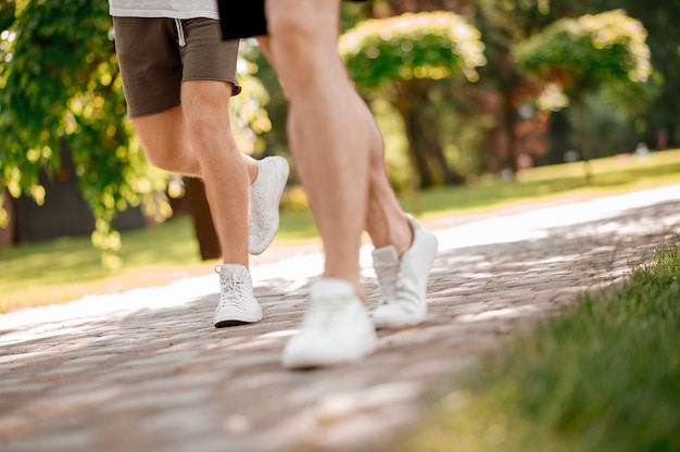 Gambe maschili che corrono lungo il sentiero del parco