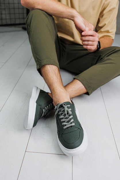 Gambe maschili in pantaloni e sneakers casual verdi Scarpe alla moda da uomo