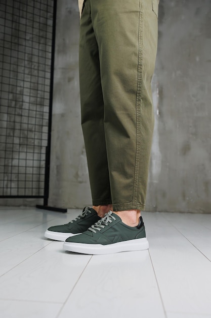 Gambe maschili in pantaloni e sneakers casual verdi Scarpe alla moda da uomo