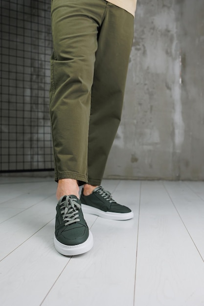 Gambe maschili in pantaloni e sneakers casual verdi Scarpe alla moda da uomo