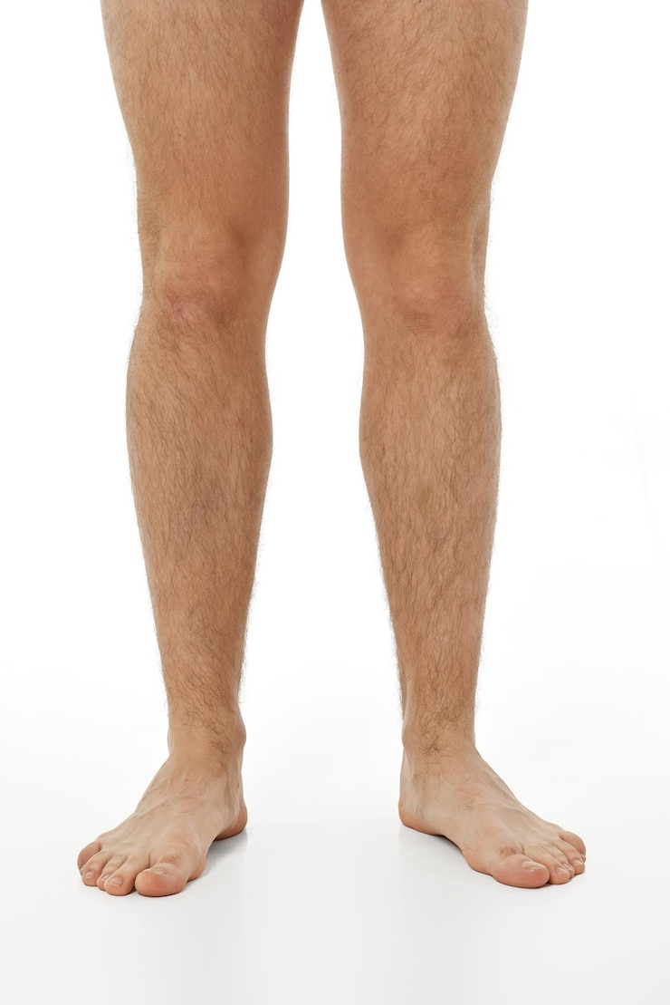 Foto gambe maschili scalze su sfondo bianco concetto di cura del corpo