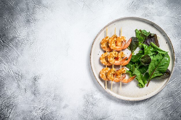 Gamberetti arrosto di gamberi su spiedini con insalata di spinaci