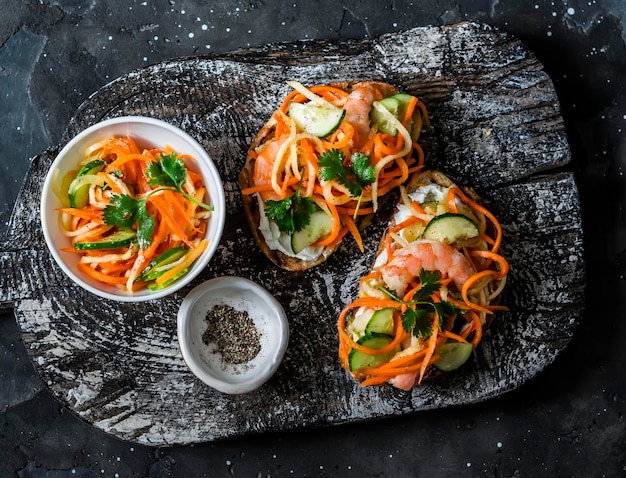 Gamberetti banh mi panini su tagliere di legno rustico su uno sfondo scuro vista dall'alto