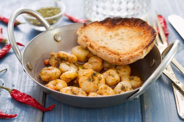 Gamberetti fritti con pane sul piatto sulla tavola blu