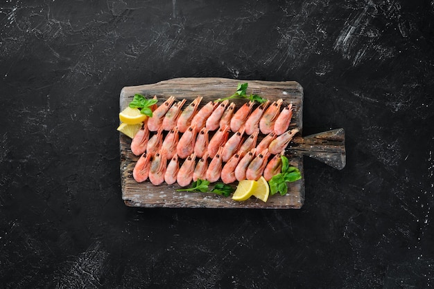 Gamberetti su una tavola di legno Frutti di mare Sullo sfondo vecchio Vista dall'alto Spazio libero per la copia