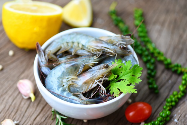 Gamberetto fresco sulla ciotola bianca e sul fondo di legno