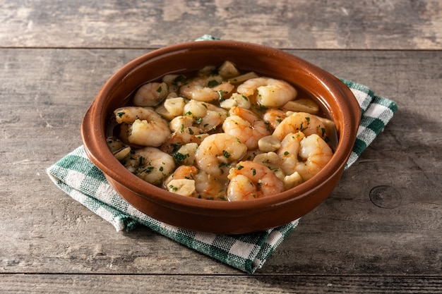 Gamberi all'aglio in crockpot sulla tavola di legno