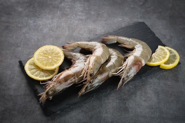 Gamberi freschi serviti su un tagliere con sfondo scuro Preparazione del cibo