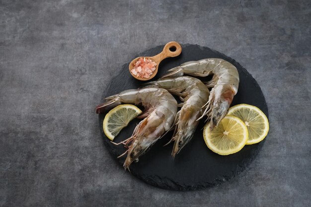 Gamberi freschi serviti su un tagliere con sfondo scuro Preparazione del cibo