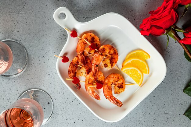 Gamberi fritti, rose e champagne. Antipasto originale per San Valentino, cena romantica. Vista dall'alto. Foto di alta qualità