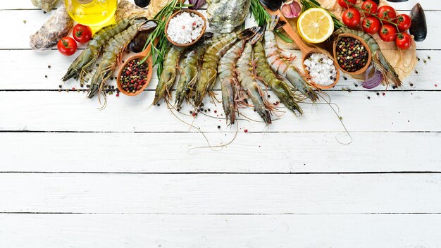 Gamberi tigre neri al limone. Frutti di mare. Vista dall'alto. Su uno sfondo di legno bianco. Spazio di copia gratuito.