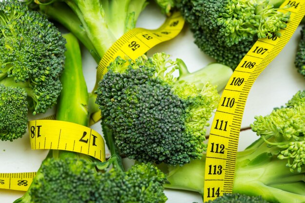 Gambi di broccoli con il metro a nastro giallo immagine ravvicinata