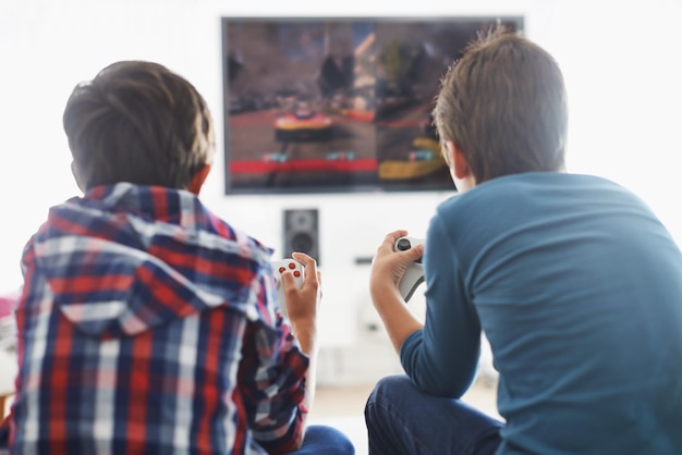 Game Time Inquadratura retrospettiva di due ragazzi che giocano a un videogioco in soggiorno