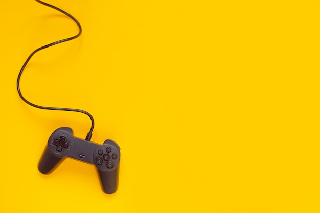 Gamepad collegato filo dalla console di gioco su giallo