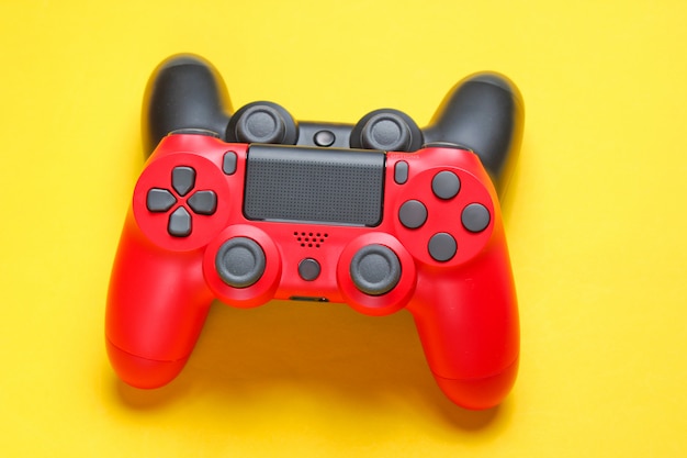 Gamepad rosso e nero sulla fine gialla del fondo su