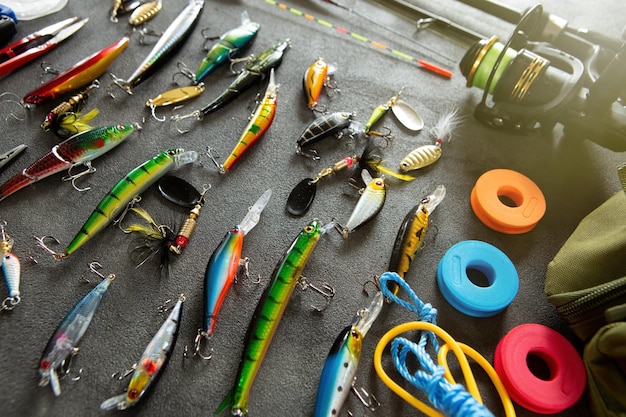 Ganci ed esche per canne da pesca per attrezzatura da pesca su sfondo grigio Concetto di ricreazione hobby attivo