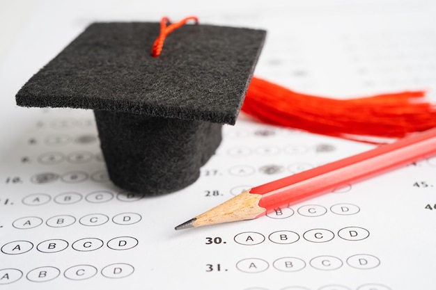 Gap di laurea cappello e matita sullo sfondo del foglio delle risposte Test di studio sull'istruzione Concetto di insegnamento dell'apprendimento