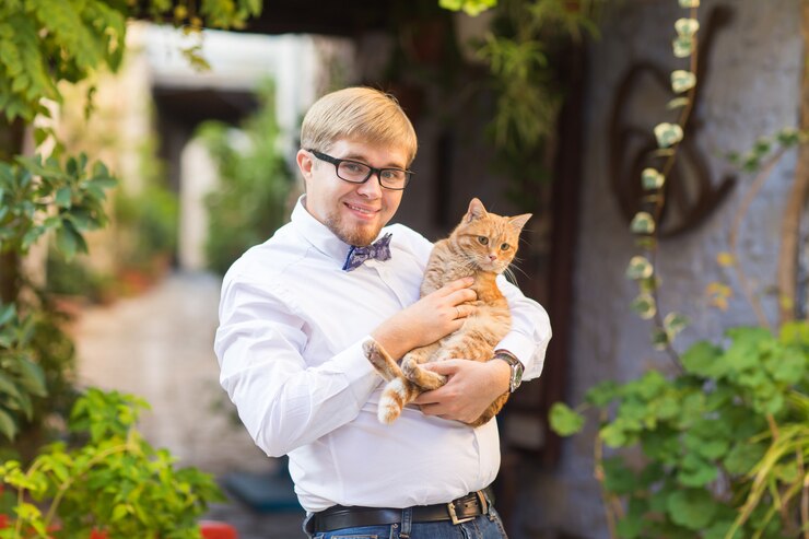 Gatto rosso nelle mani dell'uomo alla moda