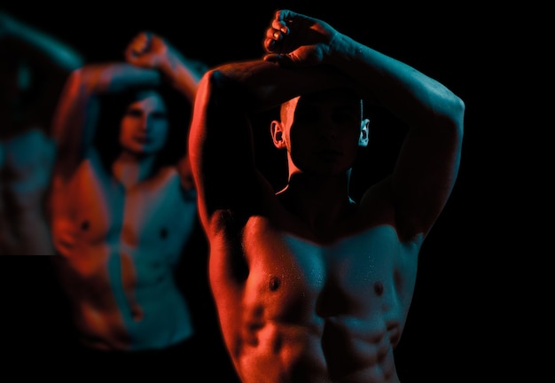 Gay corpo muscoloso Modelli muscolosi sportivi giovani uomini su sfondo scuro Ritratto di moda di ragazzi forti e brutali con muscoli corpo nudo Sexy torso nudo addominali scolpiti