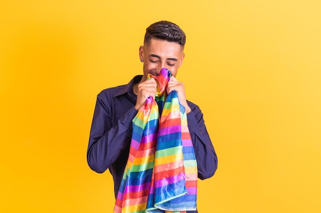 Gay Pride Ragazzo omosessuale che bacia la bandiera lgbt su sfondo giallo