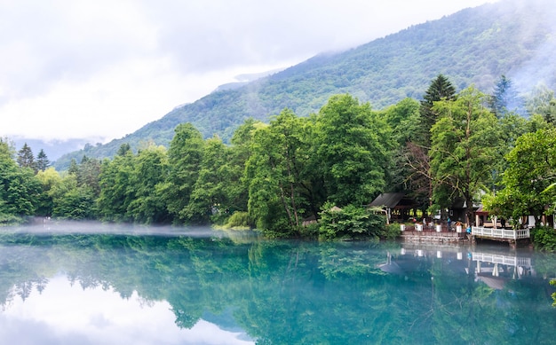 Gazebo per rilassarsi sulla riva del lago carsico blu Cerik-Kel in nuvoloso tempo nebbioso, Repubblica di Cabardino-Balcani, Russia