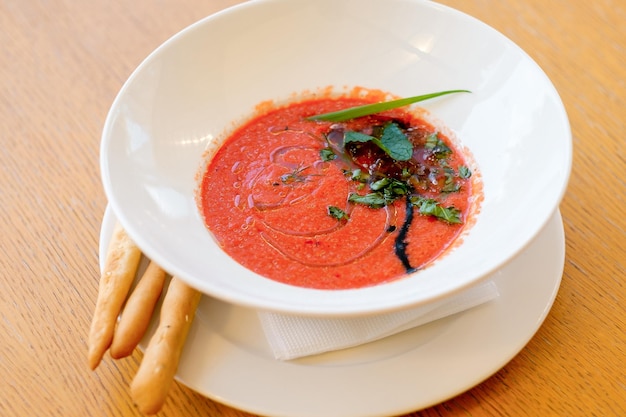 Gazpacho a base di pomodori maturi e pepe al forno Zuppa rossa con panino ed erbe aromatiche Concetto di cibo fatto in casa per un pasto gustoso e sano