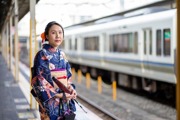 Geisha che indossa un kimono giapponese nella stazione ferroviaria di Kyoto