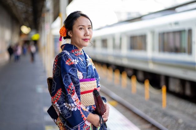 Geisha che indossa un kimono giapponese nella stazione ferroviaria di Kyoto