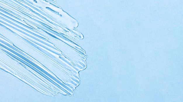 Gel di acido ialuronico trasparente su sfondo blu con banner spazio copia con texture cosmetica