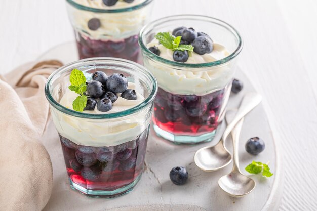 Gelatina blu fatta in casa con mirtilli crudi e panna montata