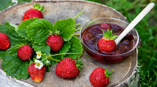 Gelatina di fragole, marmellata su fondo in legno, prodotto ecologico. Messa a fuoco selettiva