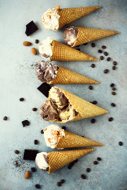 Gelato al cioccolato e caffè in cono di cialda con chicchi di caffè su pietra grigia. Concetto di cibo estivo, copia spazio. Gelato salutare senza glutine. Vista dall&#39;alto