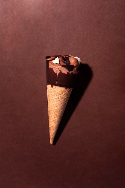 Gelato al cono di cioccolato su sfondo marrone con spazio per la copia