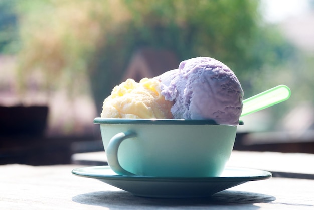 Gelato al gusto misto in una tazza verde con sfondo sfocato a bolle