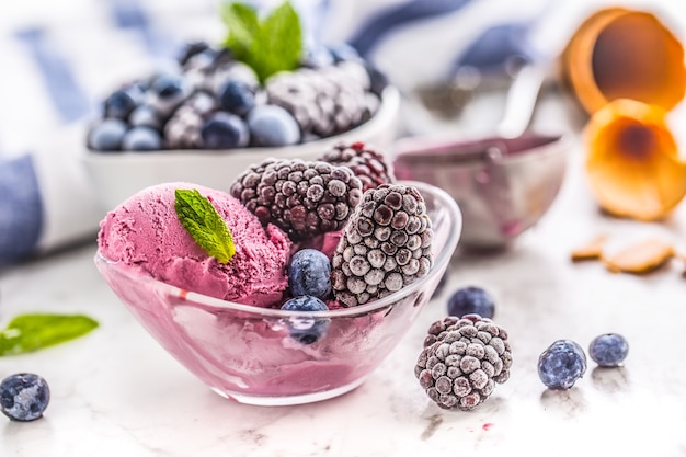 Gelato al mirtillo e mora in ciotola con frutta congelata.