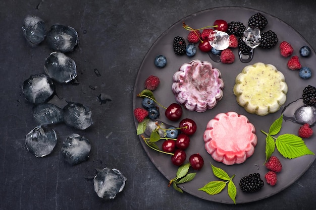 Gelato al sorbetto con frutti di bosco su sfondo nero vista dall'alto