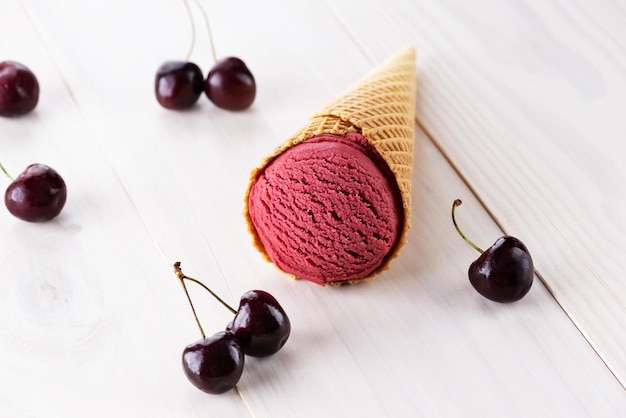 Gelato alla ciliegia in un cono su un tavolo di legno