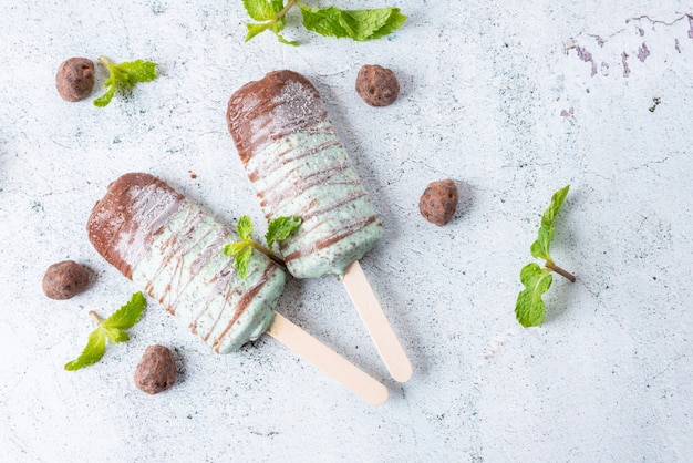 Gelato alla menta con gocce di cioccolato, ricoperto di bastoncino di cioccolato. Dessert dolce ghiacciolo e ghiacciolo. Vista dall'alto