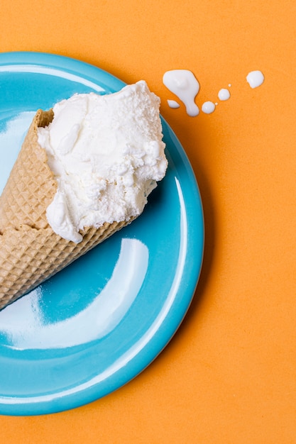 Gelato alla vaniglia bianco fuso sul piatto blu