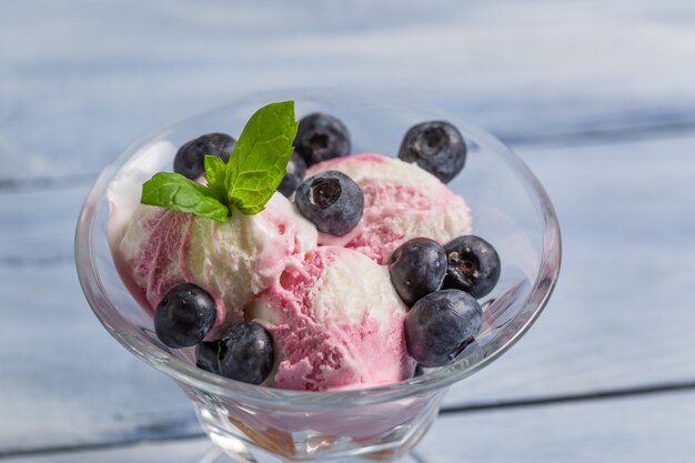 Gelato alla vaniglia con frutti di bosco sulla superficie del legno